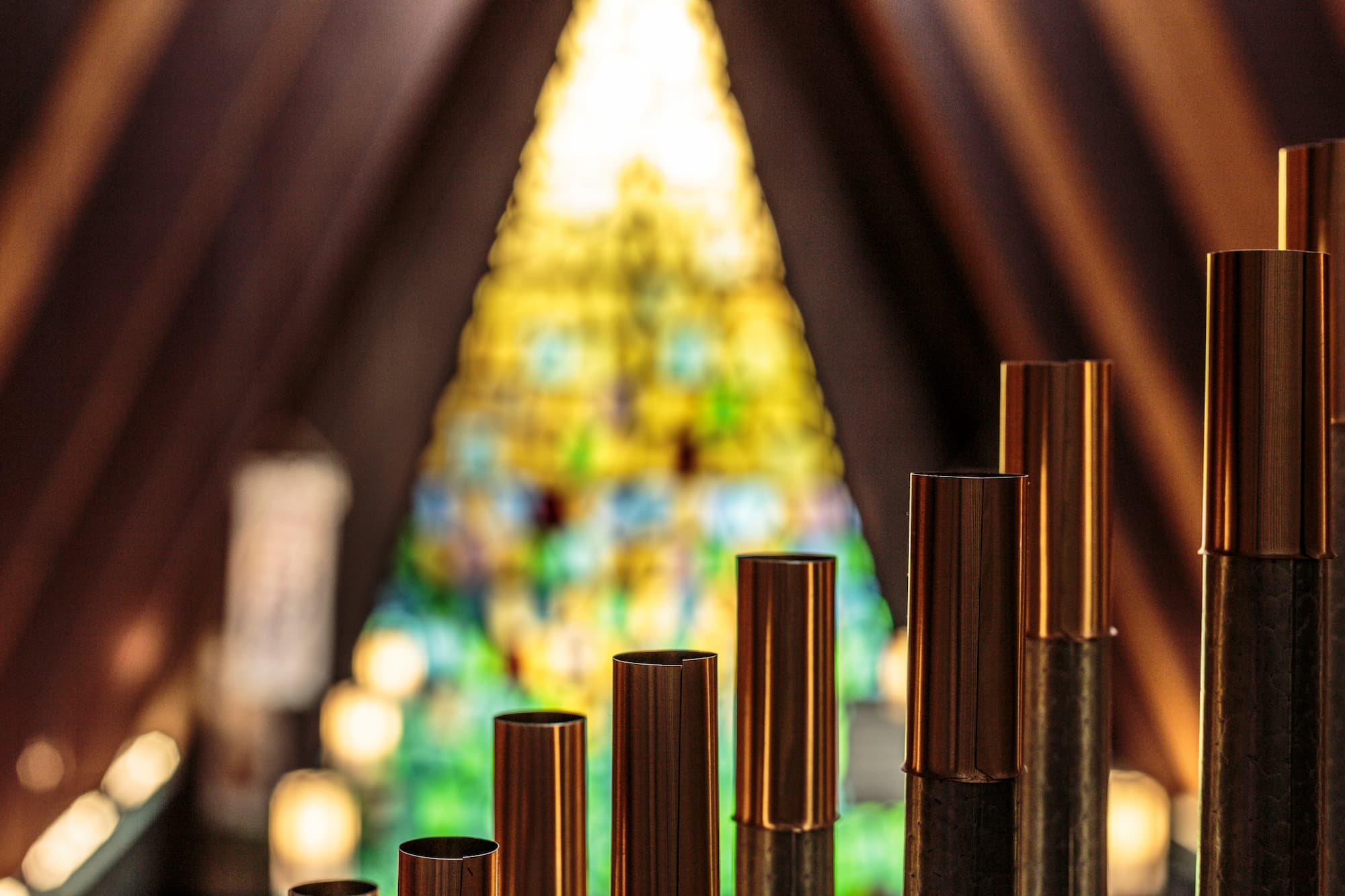 A wide interior view of Trinity Lutheran Church in Richmond, BC showing the ten-rank Wicks pipe organ in the gallery, with the chancel and distinctive A-frame stained glass windows in the background. Photo by A. Schwab